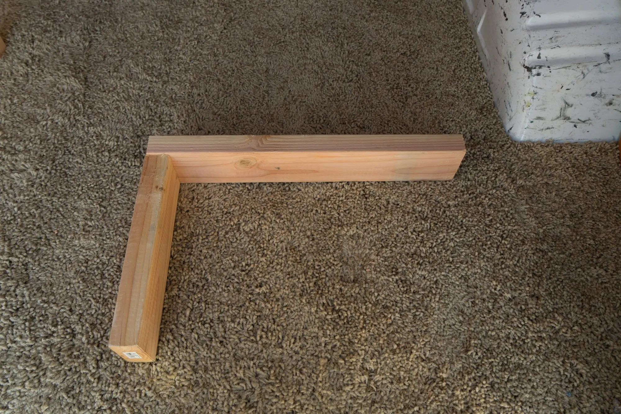 Drill 2 2x4s together making an L shape(short: 12 inches, long: 23 inches).